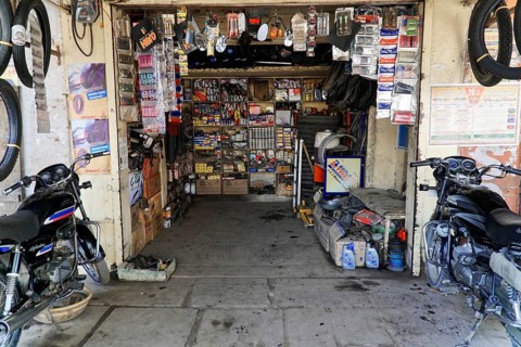 Kota, Rajasthan, North India, Asia, A small workshop shop with motorbike parts, tools and shelves