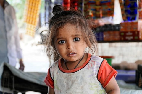 Kota, Rajasthan, North India, Asia, Little girl with a curious look in front of a colourful