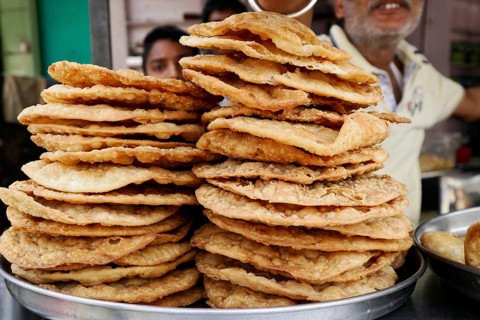 Kota, Rajasthan, North India, Asia, Stack of fried flatbreads on a market stall, India