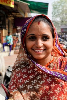 Kota, Rajasthan, North India, Asia, Smiling woman in traditional Indian sari in front of a busy