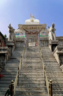 Entrance to Jagdish Temple, Udaipur, People climb the steps to a temple flanked by statues under a