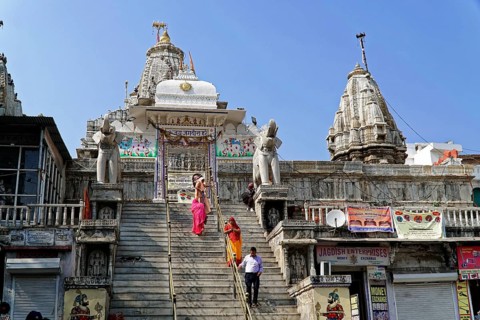 Entrance to Jagdish Temple, Udaipur, People climb the steps to a temple flanked by statues under a