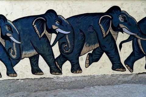 Udaipur, Rajasthan, North India, Asia, Row of painted black elephants on a light-coloured wall,
