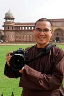 Red Fort, Agra, Uttar Pradesh, India, A smiling man with a camera stands in front of a historical