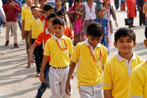 Group of children in yellow school uniforms standing happily in a row, Agra, Jodhpur, Rajasthan,