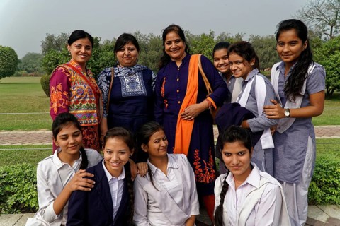 Group of female teachers and students in colourful clothes posing smiling outdoors, Agra, Jodhpur,