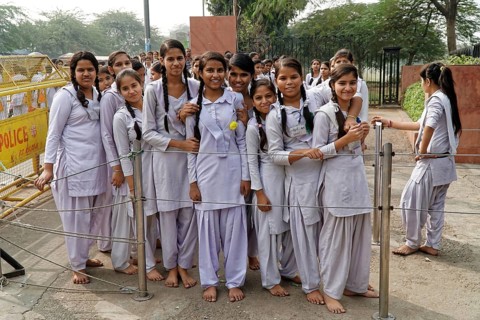 Girls in uniforms stand close together behind a protective fence, Agra, Jodhpur, Rajasthan, North
