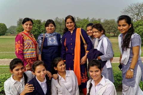Teachers and pupils laughing together in a well-tended garden, Agra, Jodhpur, Rajasthan, North