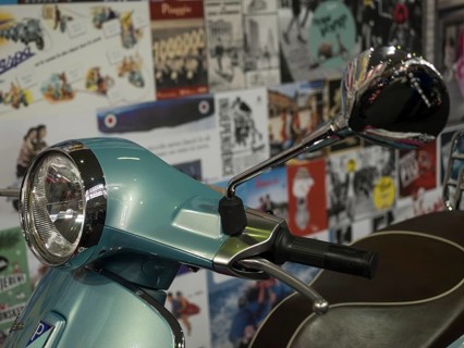 Retro scooter in blue with a chrome mirror, surrounded by billboards in the background, dortmund,
