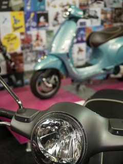 A blue retro scooter stands in an exhibition with posters in the background, dortmund, deutchland