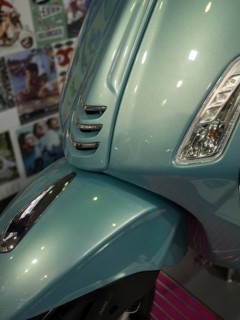 Front of a blue scooter in retro style with glossy paint and shiny chrome details, dortmund,