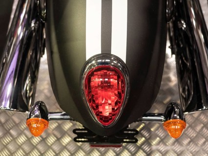 Black motorbike with red tail light and white stripes on metal floor, dortmund, deutchland