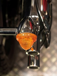 Close-up of an orange motorbike indicator with chrome details, dortmund, deutchland