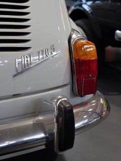 Detail of a white vintage car with tail light and bumper, gives a feeling of vintage elegance,