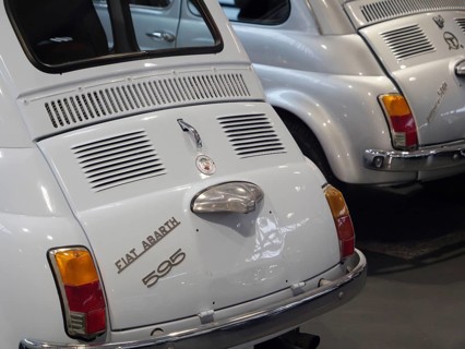 Two white Fiat Abarth vintage cars in an exhibition representing classic automotive history,