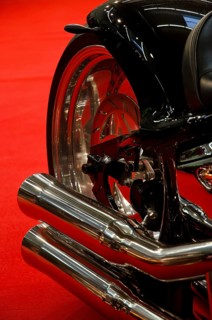 Exhaust system of a black motorbike against a red background, emphasising elegant lines, dortmund,