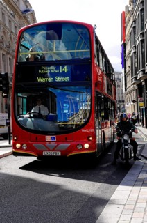 Red double-decker bus travelling along a busy London street, London, London region, England, United