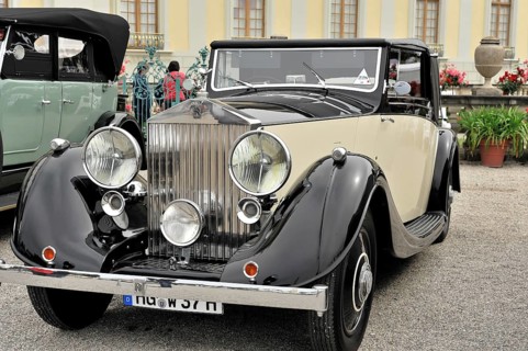 Black and cream-coloured classic car with striking front grille and round headlights, Retro