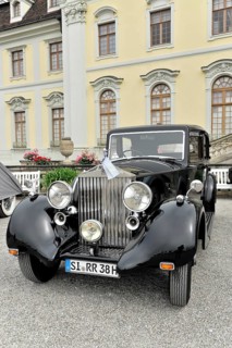 Black classic limousine-style vintage car against a historical backdrop, Retro Classics meets