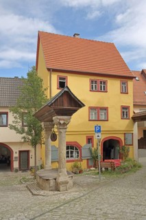 Historic council fountain built in 1583, draw well with columns and roof, house, Ochsenfurt, Lower
