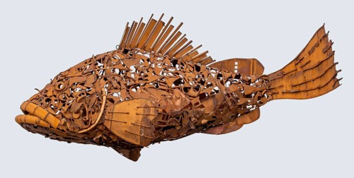 Rusty fish sculpture isolated in light back