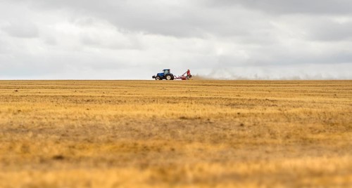 Stormy farmland scenery showing a Tractor on a stubble field in Hohenlohe, an area in Southern
