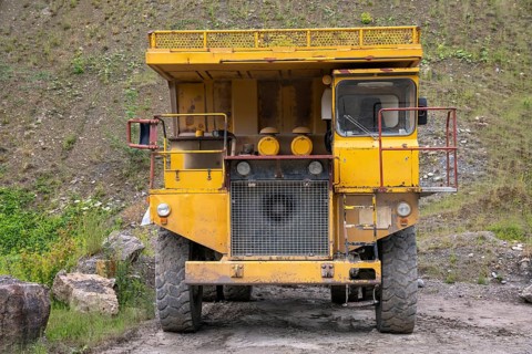 Yellow haul truck in a quarry at summer time