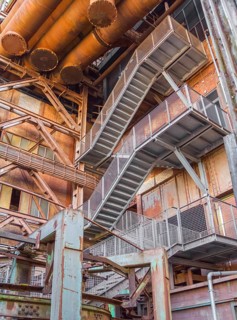 Low angle rusty industrial scenery with old corroded steel girders and metal tubes