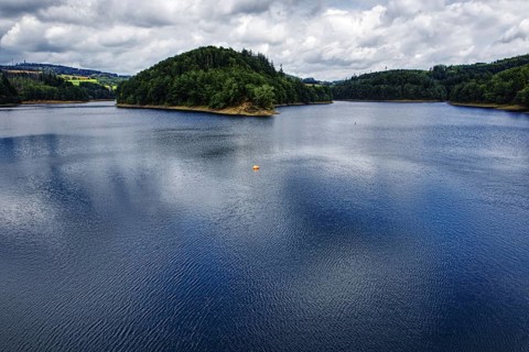 A large reservoir (Aggertalsperre) under a cloudy sky with green wooded banks, Bergneustadt