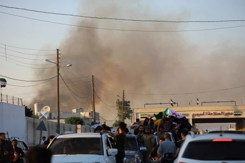 Thousands of Syrians march in Idlib carrying the Syrian revolutionary flag during a protest against