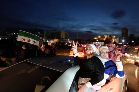 Thousands of Syrians take to public squares and main streets waving the revolutionary flag and