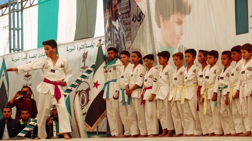 Syrians are seen demonstrating against the rule of Bashar al-Assad while carrying banners and the
