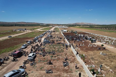 Thousands of Syrians march in Idlib carrying the Syrian revolutionary flag during a protest against