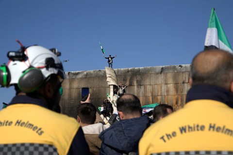 Thousands of Syrians take to public squares and main streets waving the revolutionary flag and