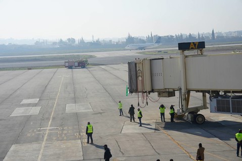 Syrians gather to welcome the first passenger plane to land at Aleppo International Airport