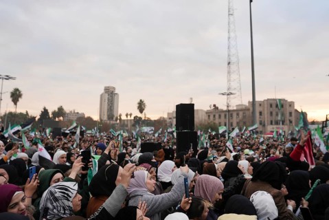 Thousands of Syrians take to public squares and main streets waving the revolutionary flag and