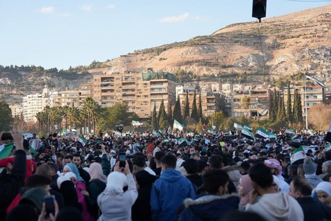 Thousands of Syrians take to public squares and main streets waving the revolutionary flag and
