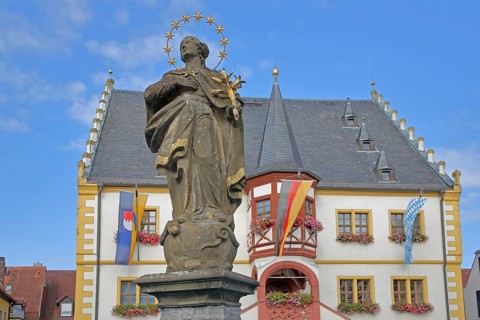 Madonna figure at the market fountain, Renaissance town hall with town flag, Bavarian state flag