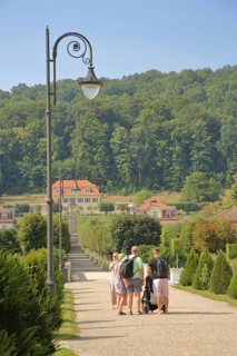 Spa gardens with tourists and pedestrians, view of Fürstenhof, street lamp, path, family excursion,