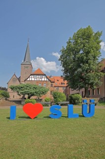 Heart sign as a symbol of solidarity and love for the city of SLÜ, monastery, church tower,