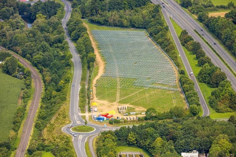 Aerial view, field with construction site for ground-mounted photovoltaic plant solar park at the