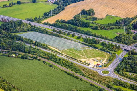 Aerial view, field with construction site for ground-mounted photovoltaic plant solar park at the