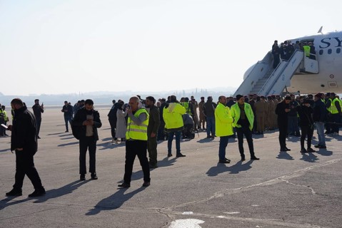 Passengers celebrate with Syrian revolutionary flags as the first flight lands at Aleppo