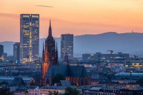Illuminated Frankfurt Cathedral, Residential Buildings and City at Evening Twilight. Aerial View.