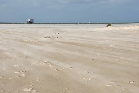 A strong storm whistles across the desert-like western beach of the North Frisian island of Amrum,