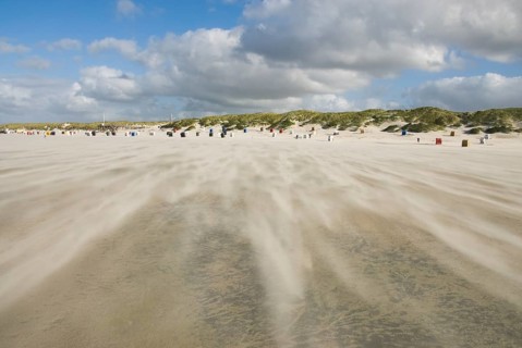 A strong storm whistles across the desert-like western beach of the North Frisian island of Amrum,