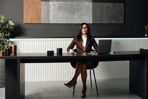 A professional lawyer dressed in formal attire sits at a sleek desk in a contemporary office