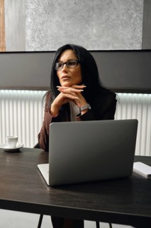 A divorce lawyer ponders strategy while sitting at a table in a modern office