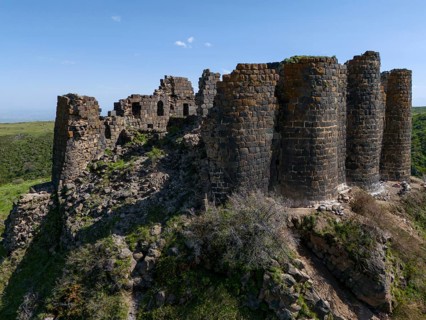 Massive ruins of a stone tower on a hill in nature, aerial view, Amberd Fortress, Aragazotn