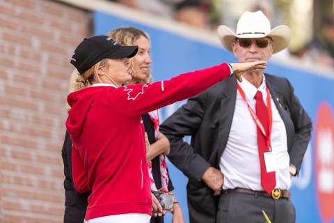 Tiffany Foster, Amy Millar and Chef d'Equipe, Ian Millar from Team Canada watch Susan Horn compete